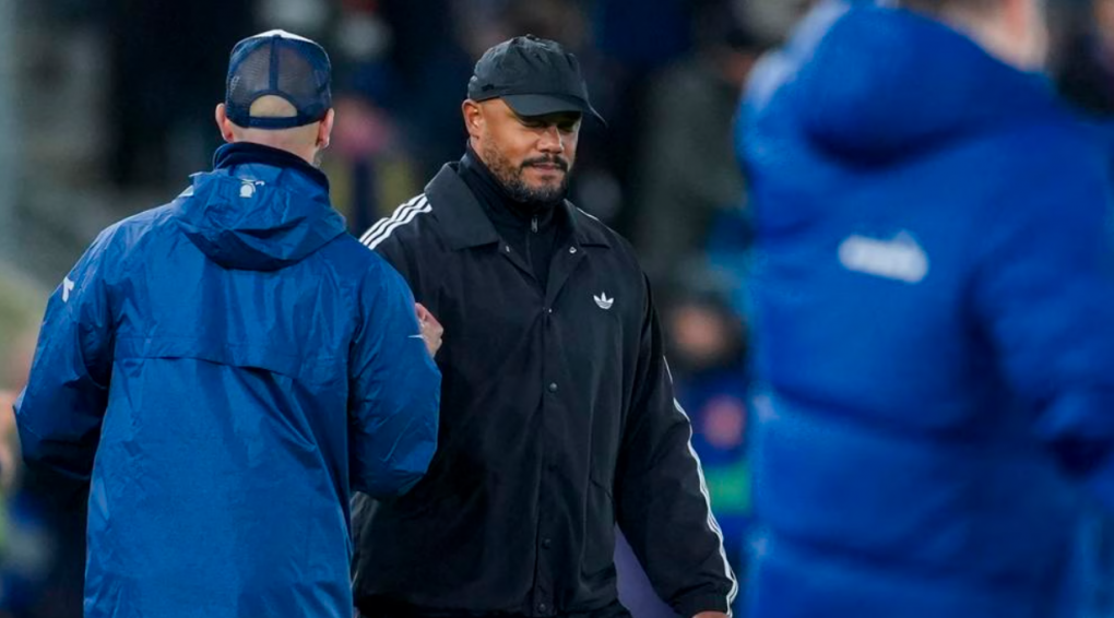 Vincent Kompany and a colleague talking at a football match